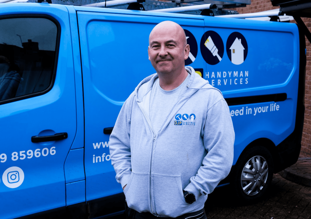 A man standing in front of a blue van