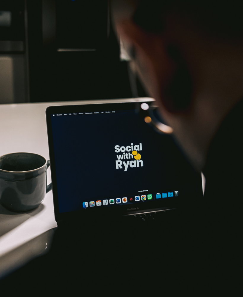 A laptop open with the 'Social with Ryan' logo